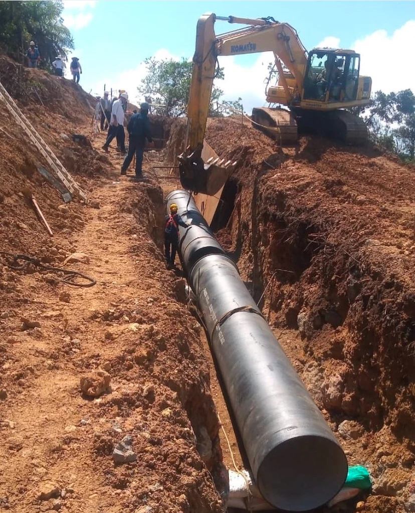 Instalación de tubería de acueducto en zanja con excavadora en obra de 5T