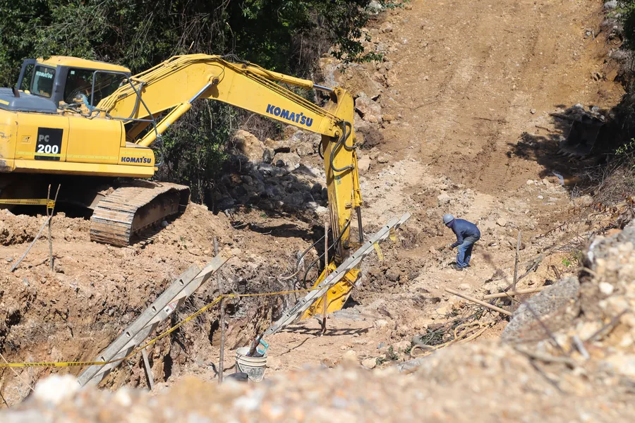 Excavadora conformando un talud en una ladera de montaña